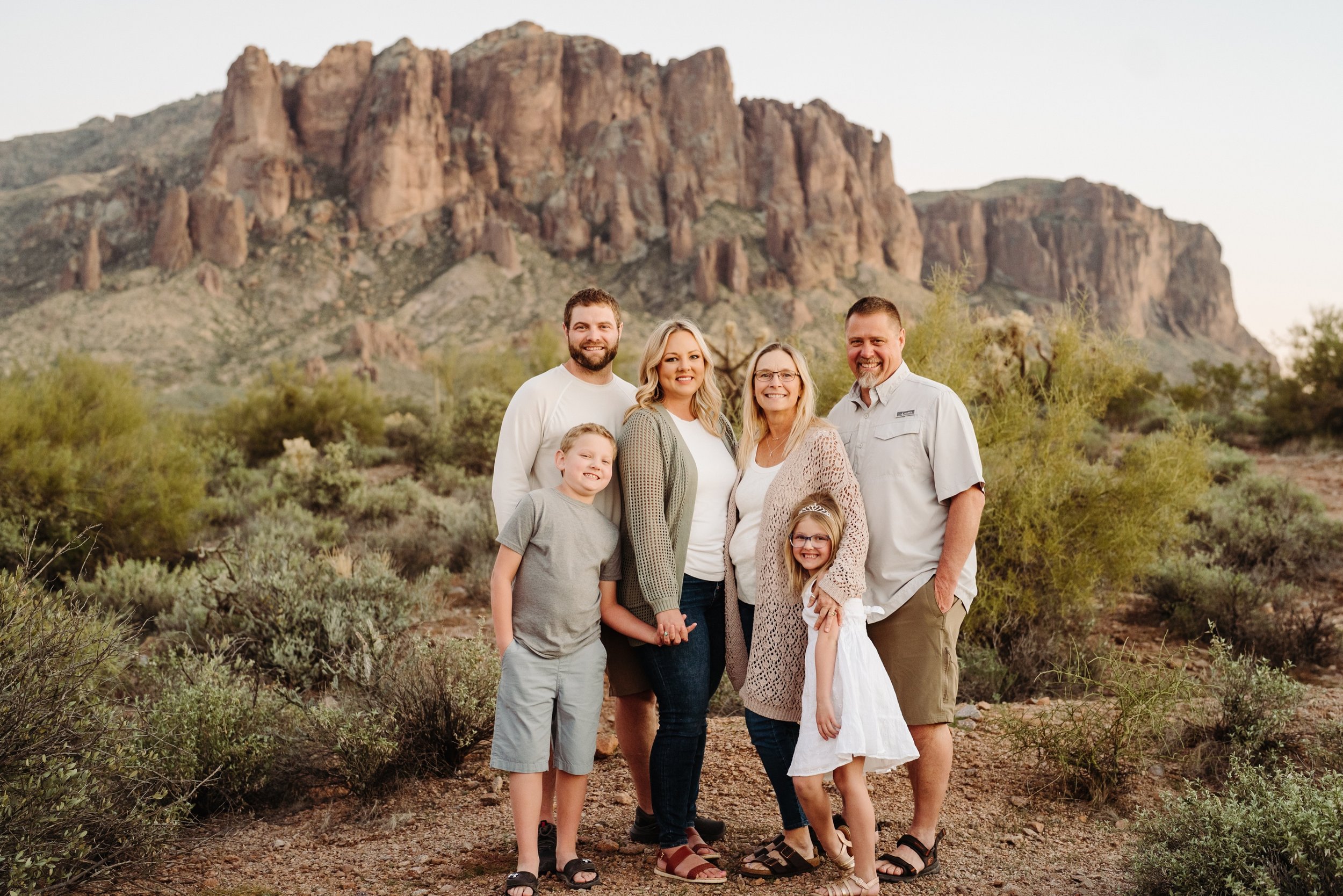 Family posing in front of Lost Dutchman State Park smiling