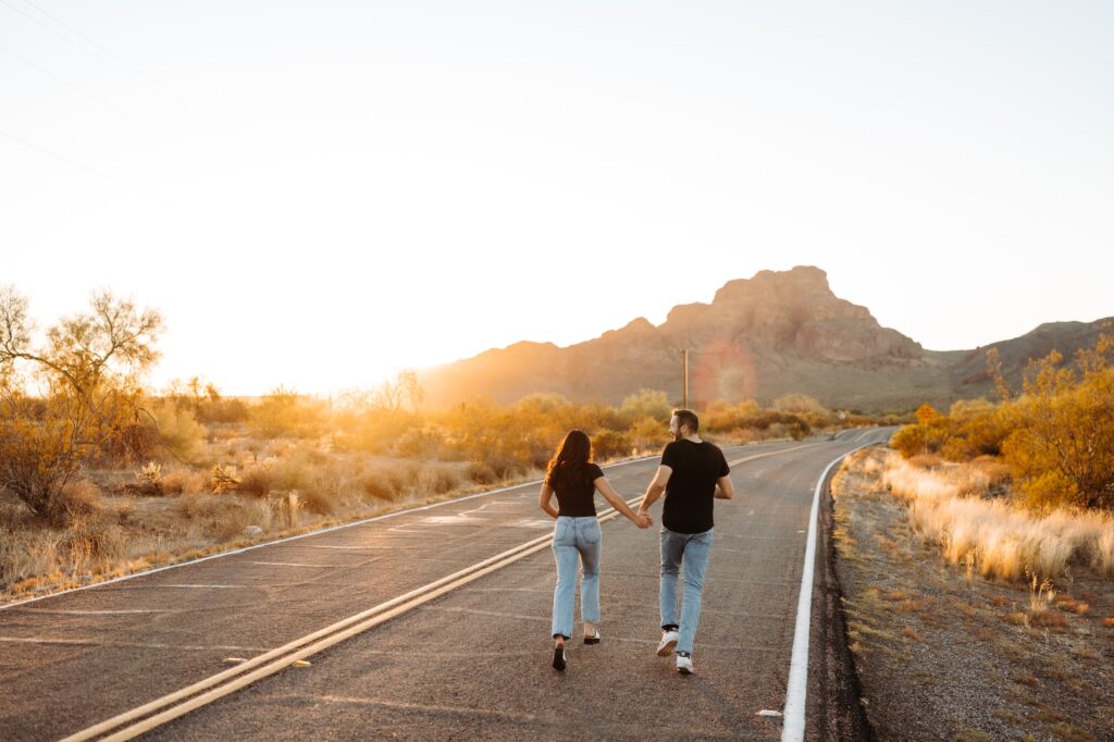 Couple running into the sunset on the road at Phon D Sutton.