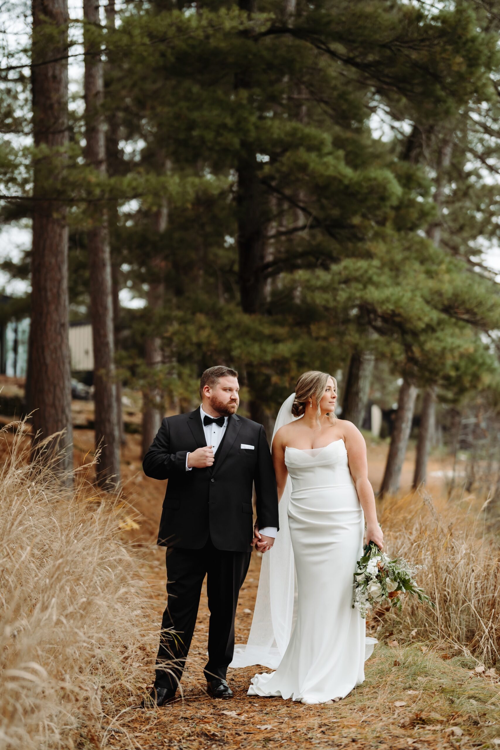 Bride and groom holding hands, looking out into the lake at Catalyst by Nature Link.