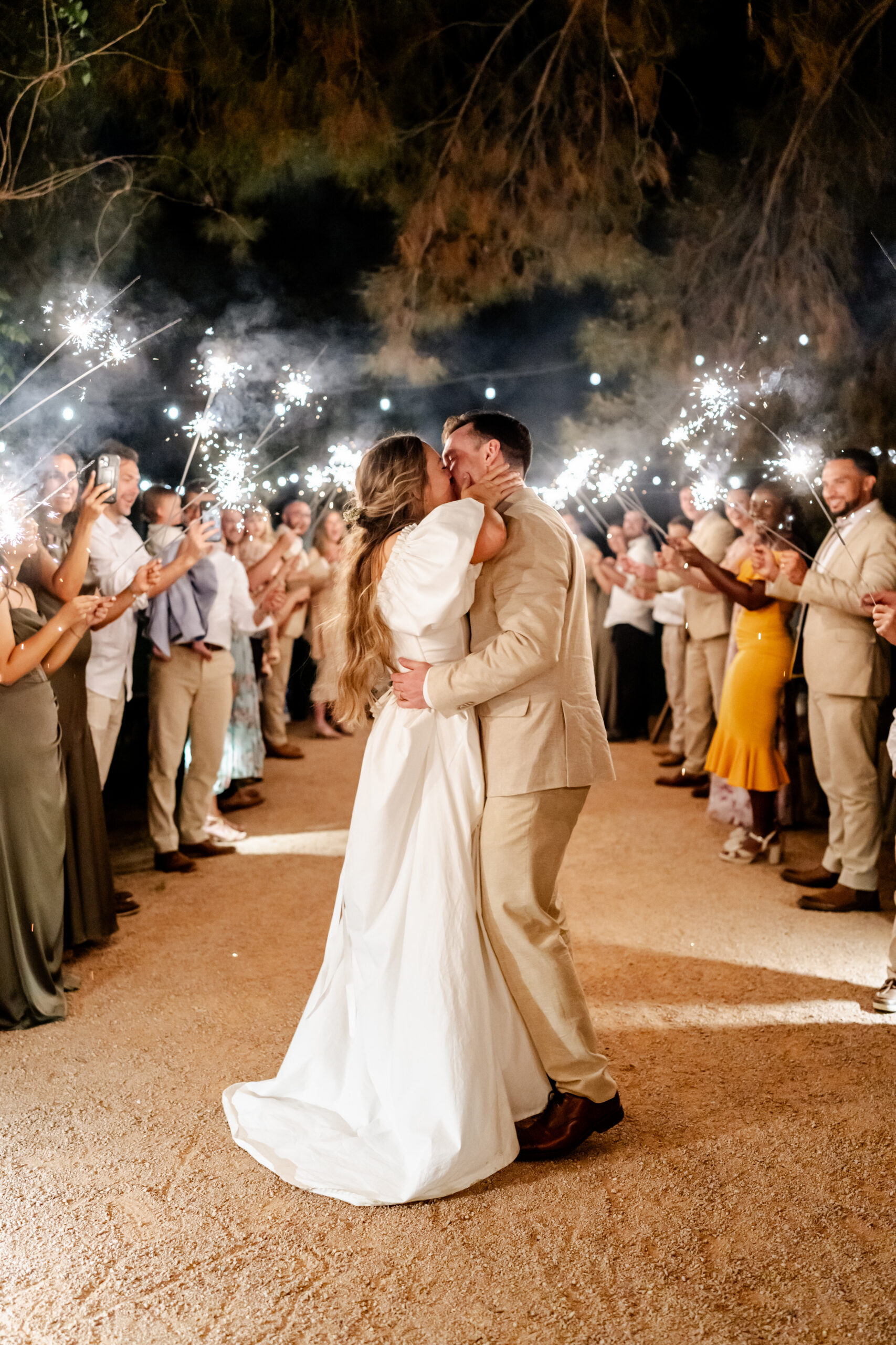 Couple kissing in the middle of sparklers at their wedding